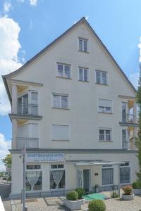 ein großes weißes Gebäude mit einem Schild davor in der Unterkunft Apart Business Hotel in Stuttgart
