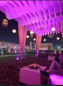 a room with purple lighting and a table with flowers at Lakshya Resort in Gorakhpur