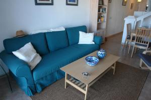 a blue couch in a living room with a table at JARDINES DE NERJA 18 MENYBER in Nerja