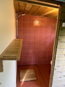 uma pequena casa de banho com uma parede de azulejos vermelhos em Willem's Huisje em Laren