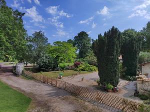 um jardim com uma cerca de pedra e árvores em Moulin de Pisseloube 