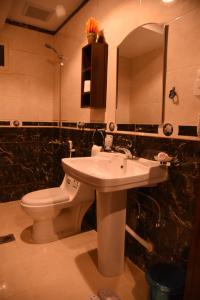 a bathroom with a white toilet and a sink at فندق الاندلس الماسى in Al Madinah