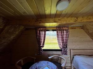ventana en una habitación con 1 cama y 2 sillas en Durmitor cottage in green field-Mountain cottage, en Žabljak