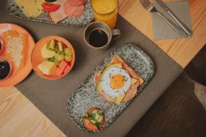 a table with two plates of food with an egg and fruit at loisi's Boutiquehotel in Achenkirch +75 photos