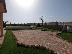 a basketball hoop in a yard with a fence at Oasis en la playa: piscina y relax in Cullera