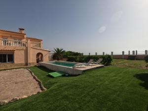 a yard with a swimming pool and a house at Oasis en la playa: piscina y relax in Cullera
