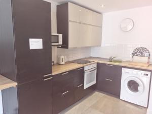 a kitchen with white cabinets and a washer and dryer at Lazydays in Puerto del Carmen