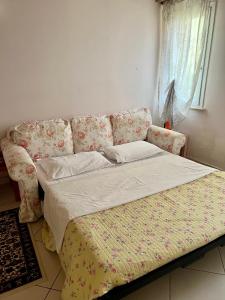 a bed in a room with a couch and a window at B&B La Pitagora in Comacchio