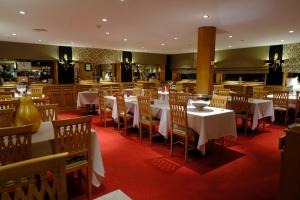 - un restaurant avec des tables et des chaises dans une salle dans l'établissement Le Chalet d'Auron, à Auron
