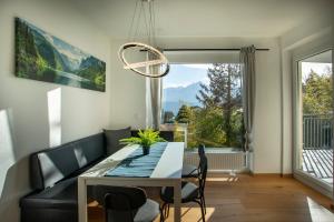 una sala da pranzo con tavolo e una grande finestra di Modern Innsbruck Mountain Apartment I Free Parking a Innsbruck