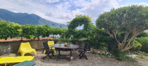eine Terrasse mit einem Tisch und Stühlen im Garten in der Unterkunft Da Ersilia in Cernobbio