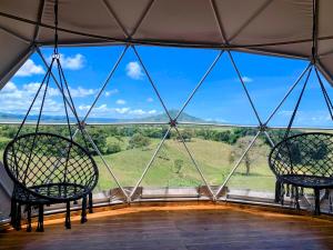 two chairs in a room with a large window at Domescape Glamping in El Cedro