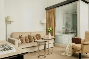 a living room with a couch and a table at Palacio de los Duques Gran Meliá - The Leading Hotels of the World in Madrid