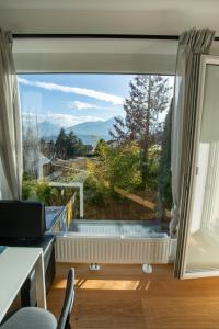 una camera con una grande finestra con vista di Modern Innsbruck Mountain Apartment I Free Parking a Innsbruck