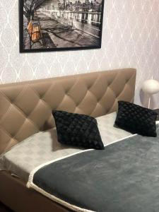 ein Bett mit zwei schwarzen Kissen darüber in der Unterkunft Luxury for Business & Pleasure Royal in Dnipro