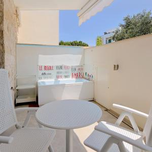 un patio con tavolo, sedie e parete di Guest House Aurora Polignano a Polignano a Mare