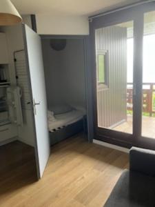 Cette chambre dispose d'une porte coulissante en verre avec un lit. dans l'établissement Appartement d'une chambre avec terrasse amenagee a L'Alpe d'Huez, à L'Alpe-d'Huez
