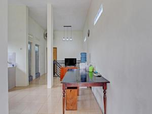 ein Esszimmer mit einem Tisch in der Mitte eines Raumes in der Unterkunft OYO 92617 Omahku Homestay Hostel in Yogyakarta