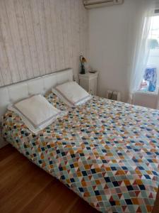 a bedroom with a bed with a colorful quilt at Monleon Villa a 10 minutos de la playa 2 parking gratuito in Roses
