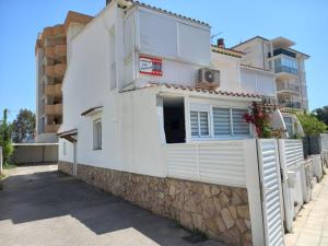 a white house with a fence and a building at Monleon Villa a 10 minutos de la playa 2 parking gratuito in Roses