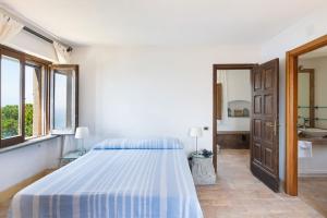 een witte slaapkamer met een bed en een wastafel bij Torre del Saraceno in Massa Lubrense