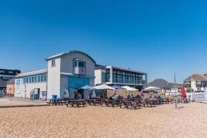 a group of tables and umbrellas on a beach at Driftwood Cottage by Bloom Stays in Folkestone