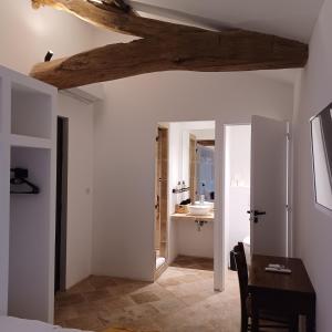 een slaapkamer met een tafel en een badkamer met een wastafel bij Château du Souzy in Quincié-en-Beaujolais