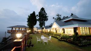 a resort with a table and chairs in the yard at Mayfair Manor Jungpana in Darjeeling