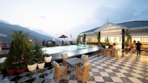 a patio with a pool and chairs and a building at Mayfair Manor Jungpana in Darjeeling