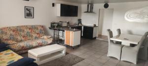 uma sala de estar com um sofá e uma cozinha em Location maison avec piscine privée. em Agde