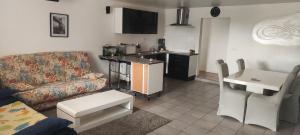 a living room with a couch and a kitchen at Location maison avec piscine privée. in Agde