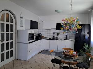 a kitchen with white cabinets and a glass table at Apartment Summer in Šibenik