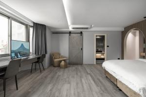 een slaapkamer met een bed en een bureau bij Chapter 127 in Tainan