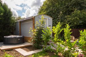 a small shed with a trash can in a garden at Elsie's Retreat in Durham +16 photos