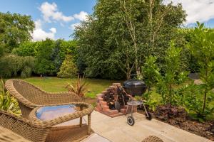a grill and chairs on a patio in a garden at Elsie's Retreat in Durham
