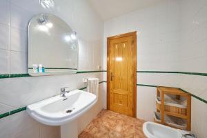 a white bathroom with a sink and a mirror at Casa Lalu in San José