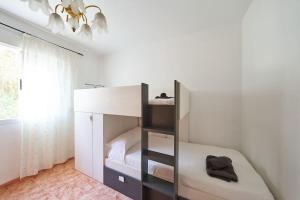 a white bedroom with a bunk bed and a window at Casa Lalu in San José