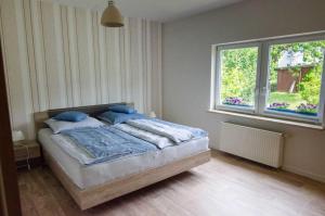 Un dormitorio con una cama con almohadas azules y una ventana en Ferienhaus Luette_ en Lohme
