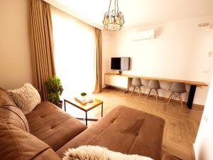 a living room with a couch and a tv at LaCasa Apartments Ulcinj in Ulcinj