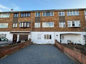 a brick building with a driveway in front of it at Modern & Spacious Terrace House in Friern Barnet