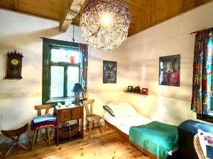 a bedroom with a bed and a desk and a chandelier at Wakacyjny Dom Letni in Ostrówek