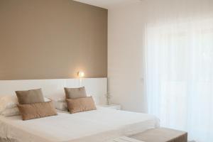 a bedroom with a large white bed with two pillows at Maison R Boutique in Reggio di Calabria