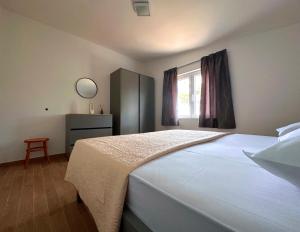 ein Schlafzimmer mit einem großen weißen Bett und einem Fenster in der Unterkunft La Isla in Tkon
