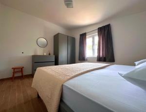 a bedroom with a large white bed and a window at La Isla in Tkon +13 photos