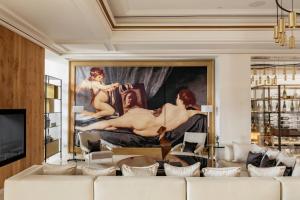 a living room with a large painting on the wall at Palacio de los Duques Gran Meliá - The Leading Hotels of the World in Madrid