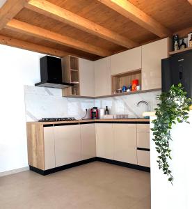 a kitchen with white cabinets and a black refrigerator at La Isla in Tkon