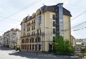 un gran edificio amarillo con techo negro en Avalon Palace, en Ternopilʼ