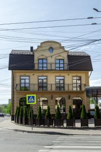 ein großes gelbes Gebäude mit Balkon darüber in der Unterkunft Avalon Palace in Ternopil