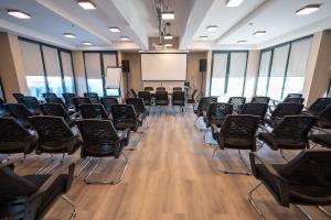 una sala de conferencias con sillas y una pantalla y a bordo en Hotel Verticalplus en Haskovo