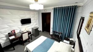 a bedroom with a bed and a desk and a television at Za'faron Hotel in Jizzax